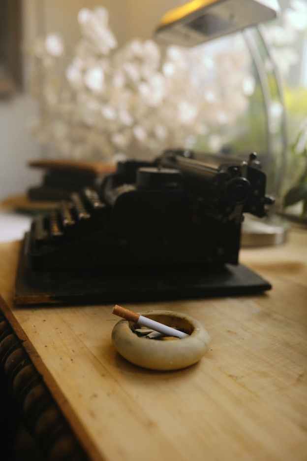 A typewriter and a cigarette in ashtray